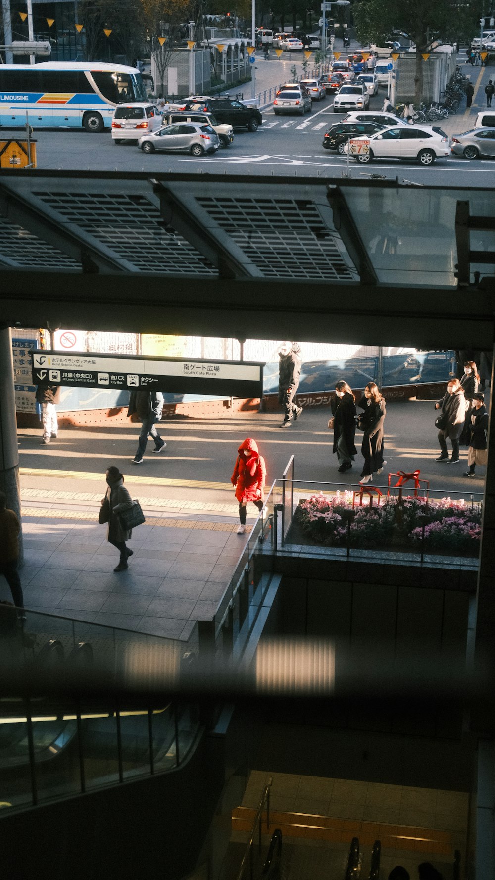 a group of people walking down a street next to a train station