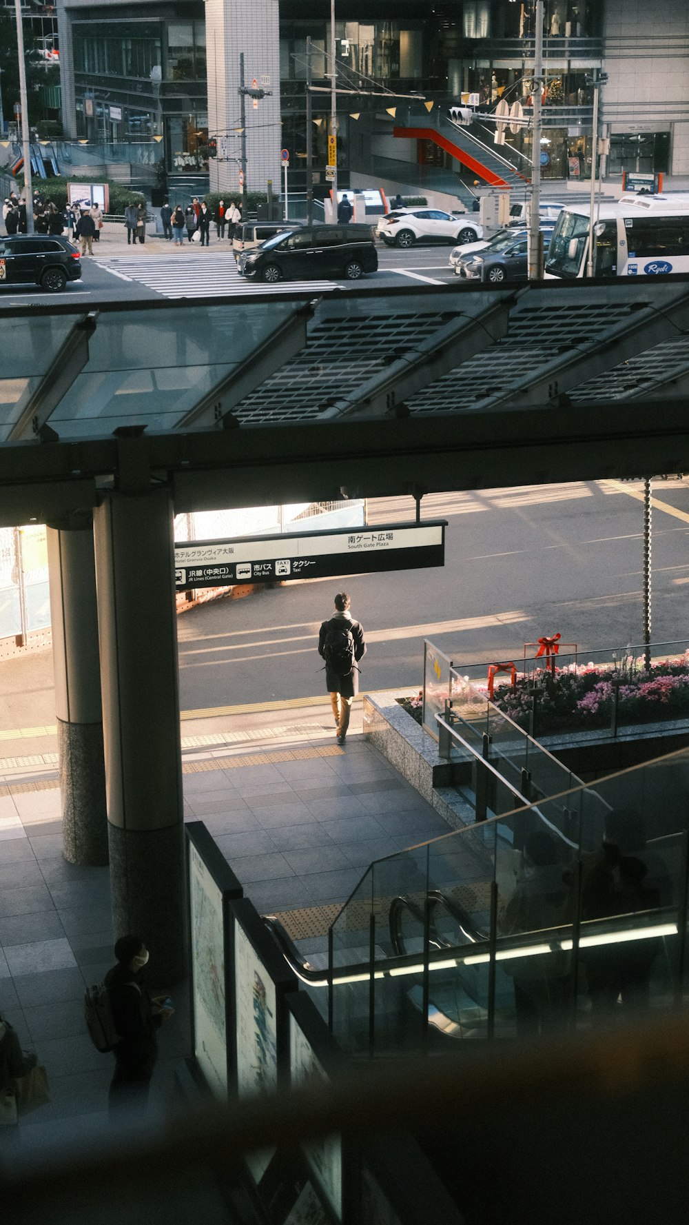 a man walking down a street next to a tall building