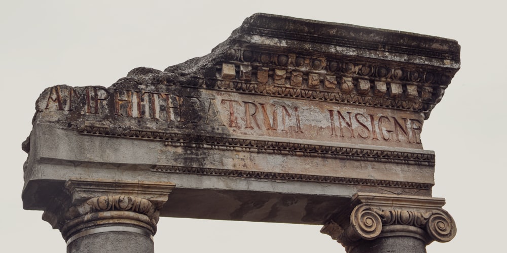 a close up of a stone arch with a sign on it