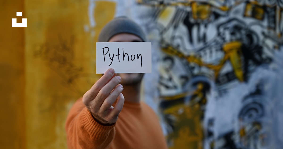 A man holding up a sign with the word python written on it photo – Free ...