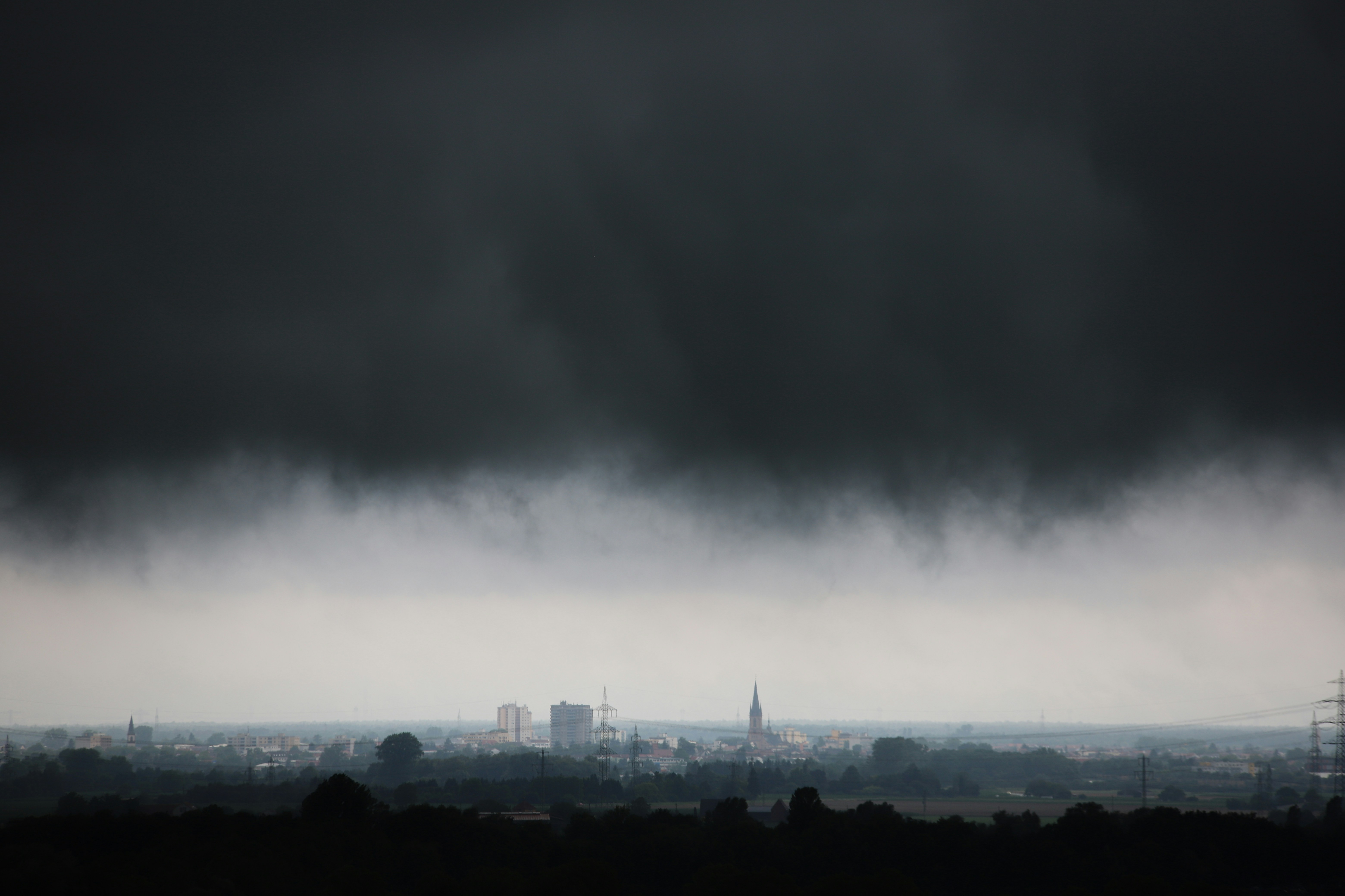 Una nube negra se cierne sobre una ciudad en la distancia