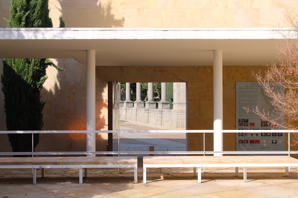 a white bench sitting in front of a building