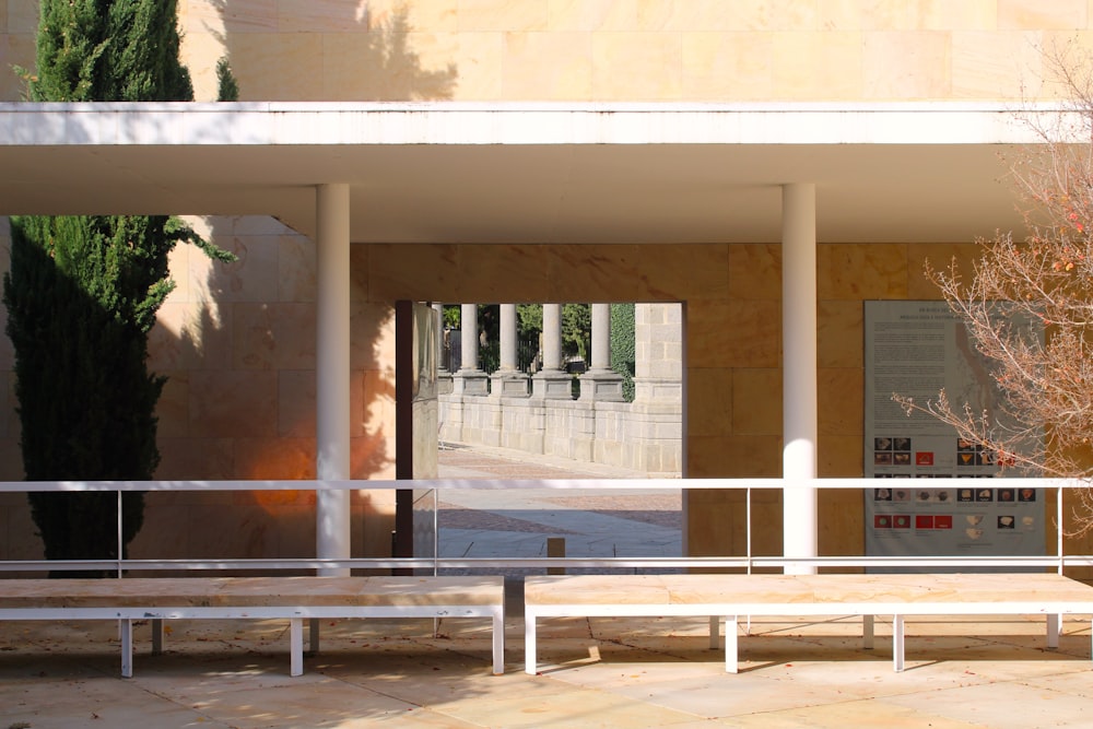 un banc blanc assis devant un bâtiment