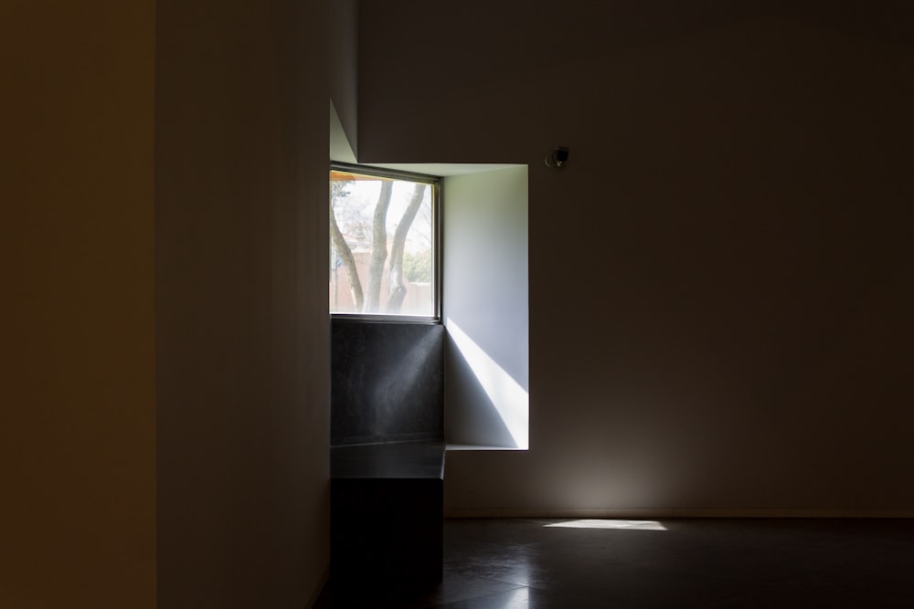 a dark room with a light coming through a window