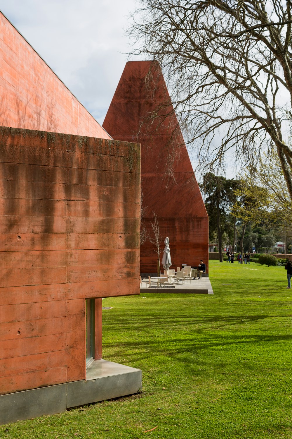 a grassy area with a building and a statue