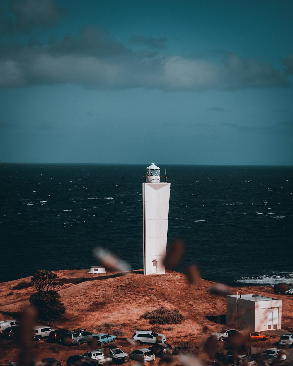 a lighthouse on top of a hill near the ocean