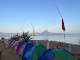 Volunteers setting up a refreshment station with colorful banners near a lakeside path.