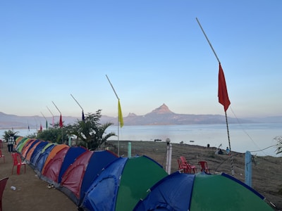 Volunteers setting up a refreshment station with colorful banners near a lakeside path.