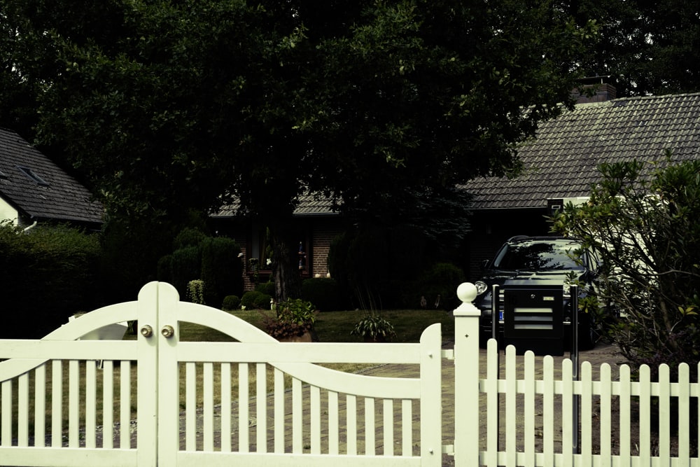 a truck parked in front of a white fence