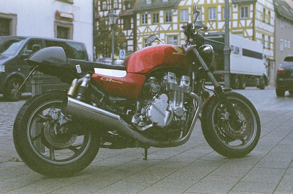 a red motorcycle parked on the side of a street