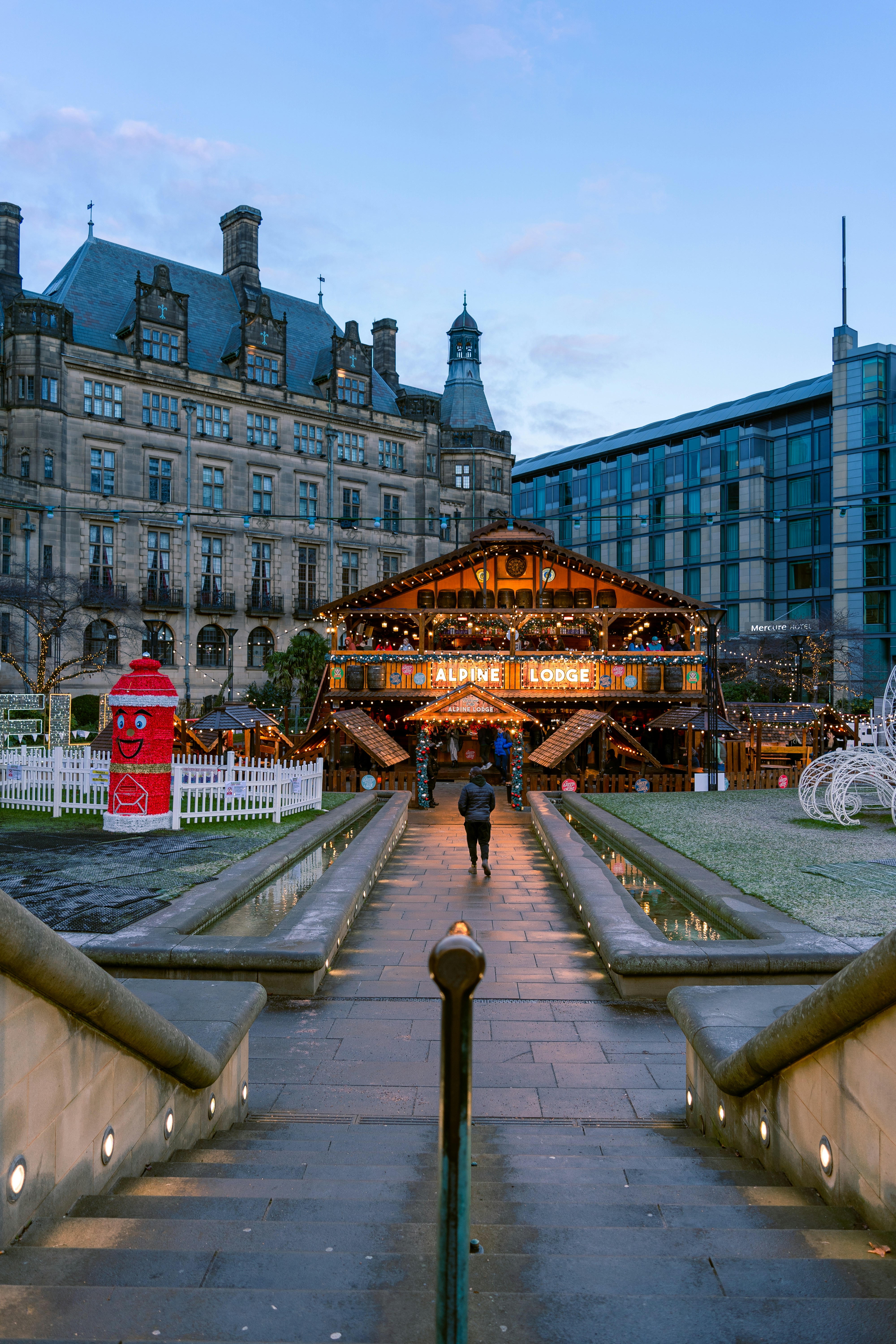 A walkway leading to a large building with a clock tower in the ...