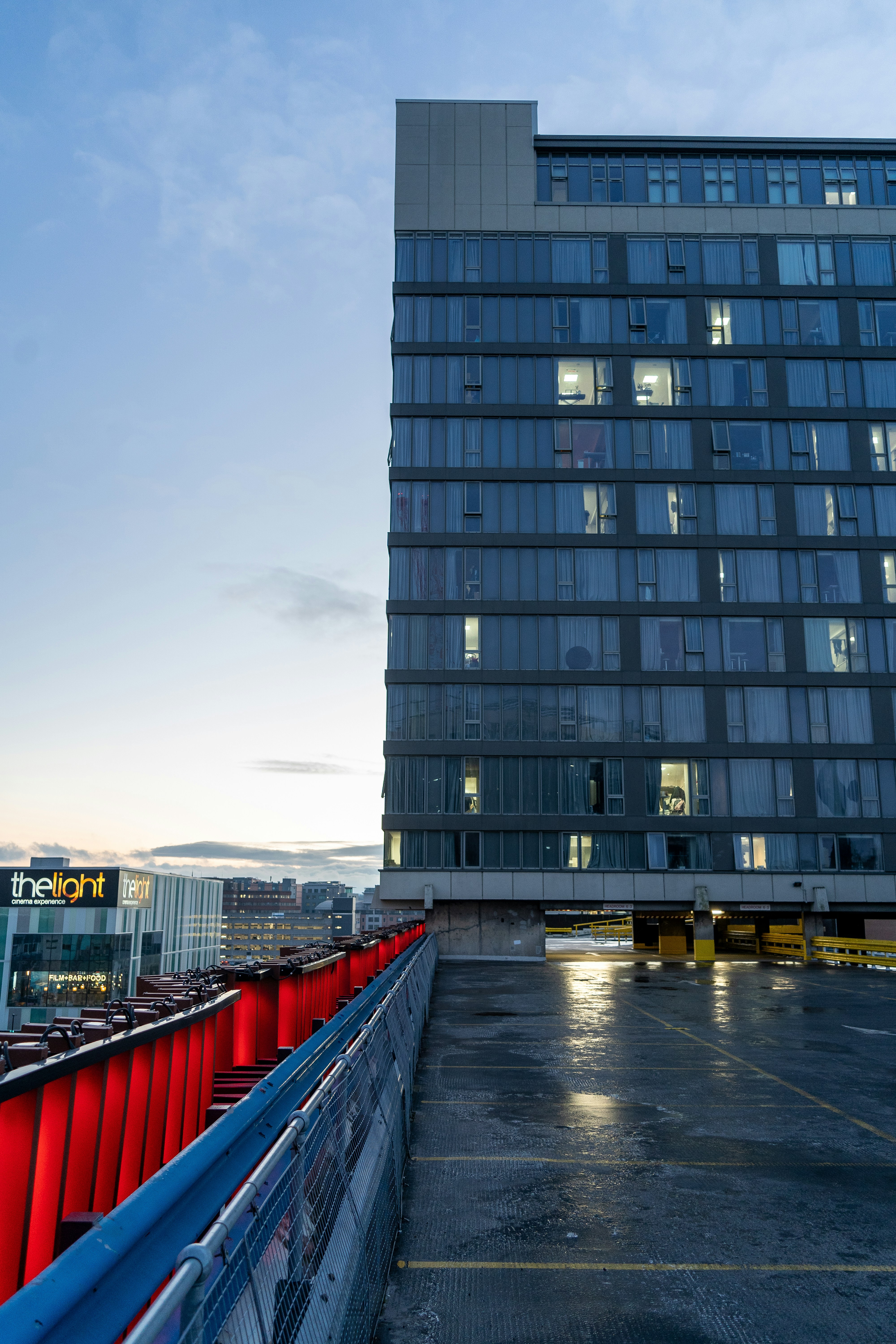 a tall building with lots of windows next to a parking lot
