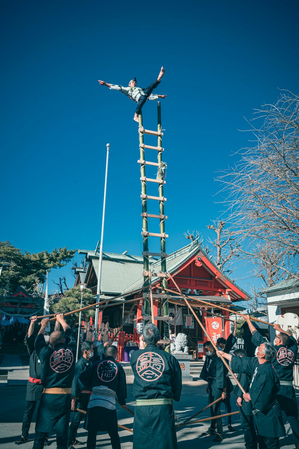 a group of people standing around a man on a ladder