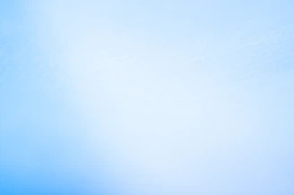 a blurry photo of a blue sky with a plane in the distance