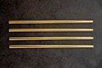 a group of four gold colored straws sitting on top of a table