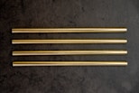 a group of four gold colored straws sitting on top of a table