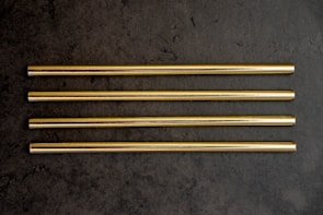 a group of four gold colored straws sitting on top of a table