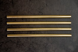 Titanium straw and wheat straw guide displayed elegantly on a dark surface.