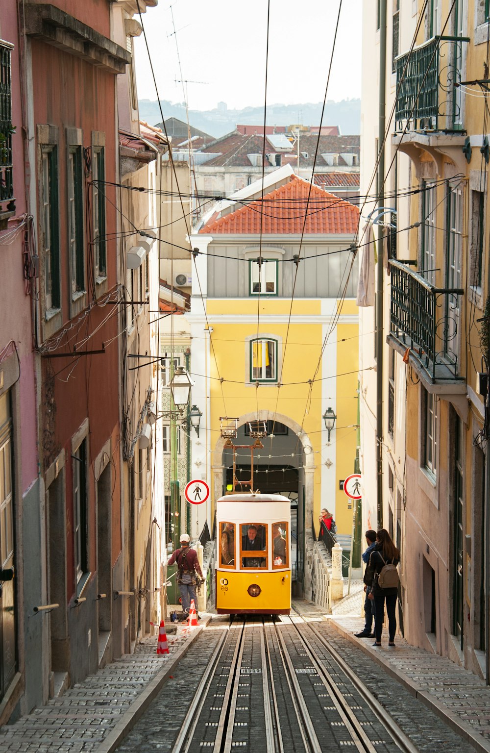 a yellow trolley is coming down the tracks