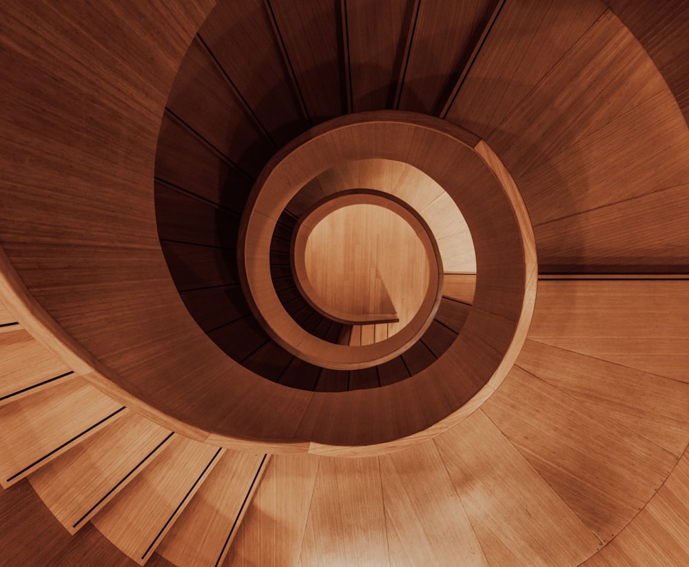 a wooden spiral staircase with a light at the end
