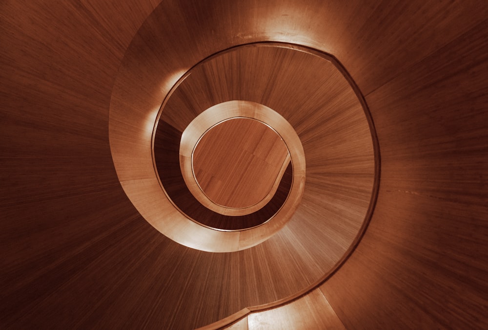 a wooden spiral staircase with a light at the top