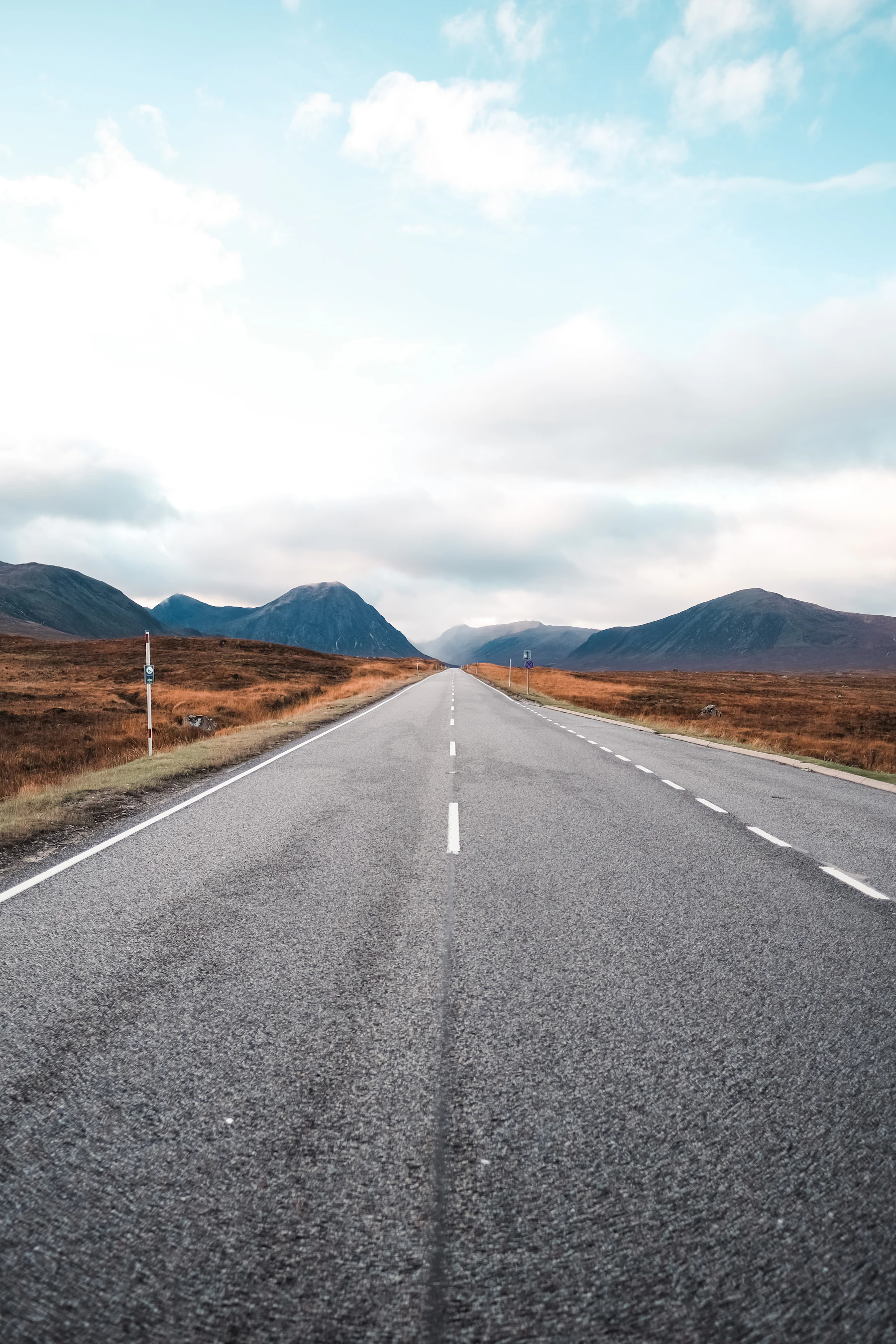 An empty road running through the misty Scottish Highlands