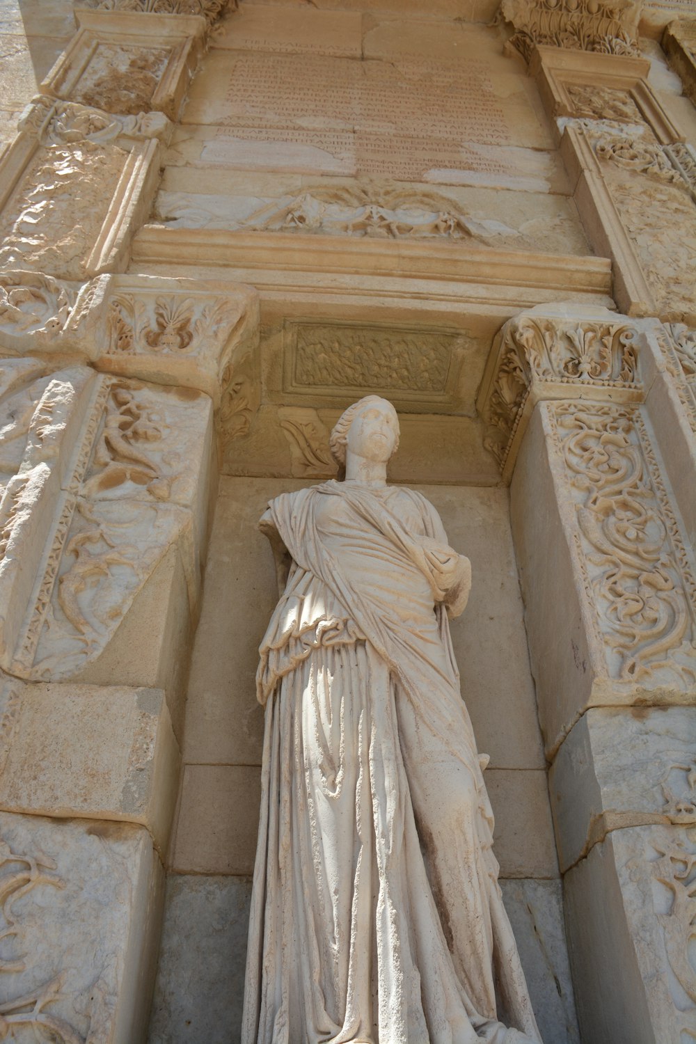 uma estátua de uma mulher em pé na frente de um edifício