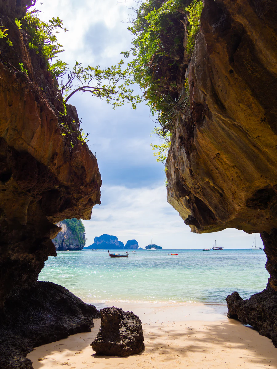 Blick durch zwei Kalksteinfelsen auf den Strand bei Railay