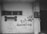 A black and white mural on a wall features a large graphic of a comb shaped like a bone above a simple line drawing of a dog. The words 'Pet Grooming' are prominently displayed next to a large paw print. The wall has a small window with bars, and there is some plumbing and an electrical box on the right.