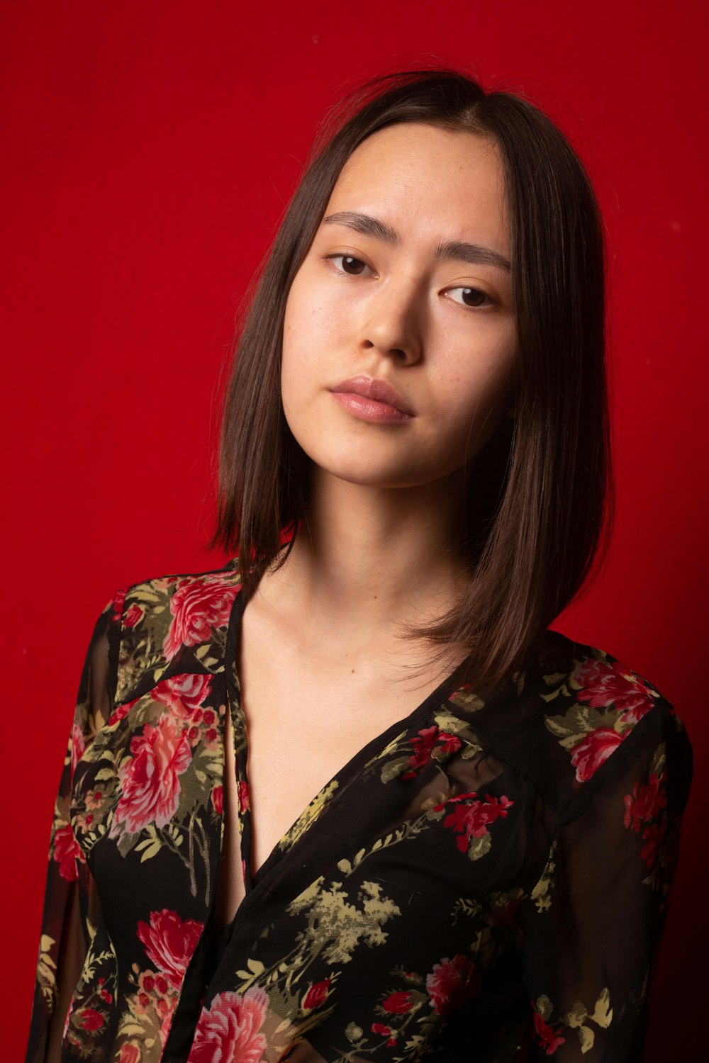 uma mulher em uma camisa floral posa para uma imagem