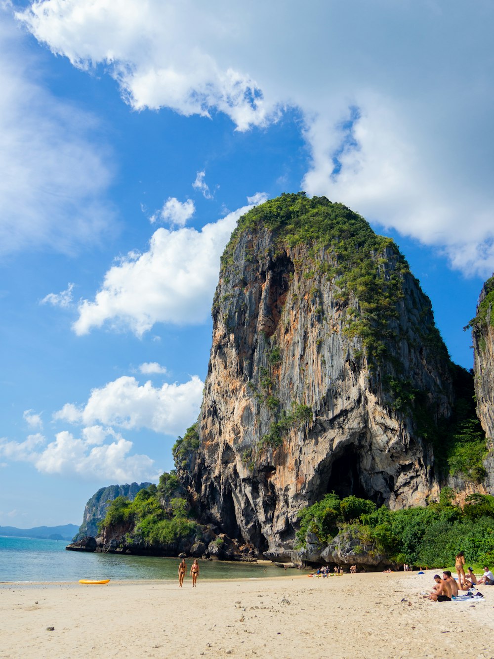 a group of people sitting on top of a sandy beach