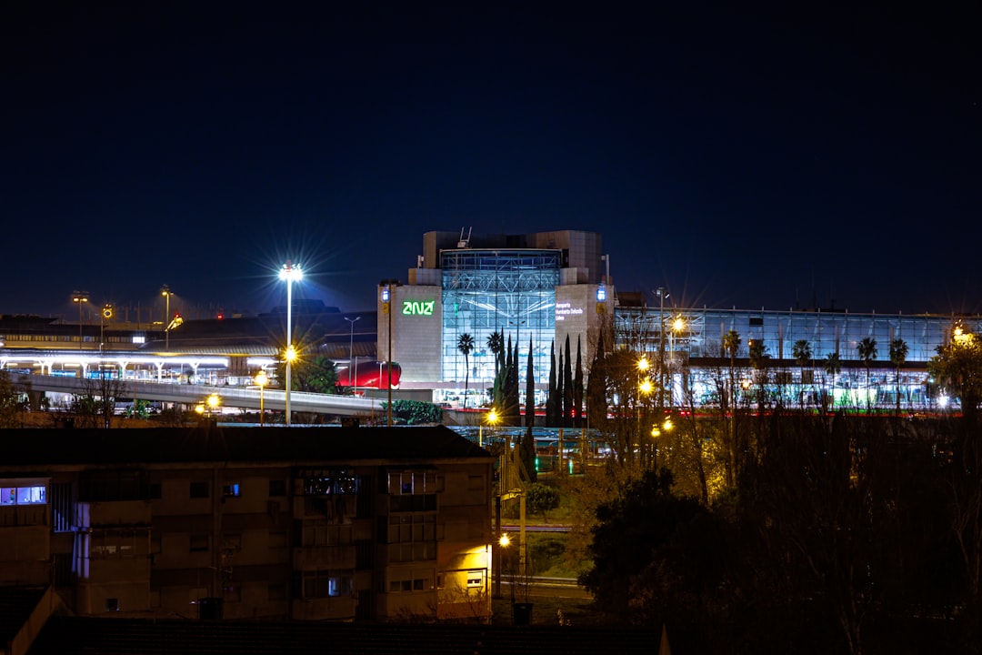 a city at night with a train on the tracks,