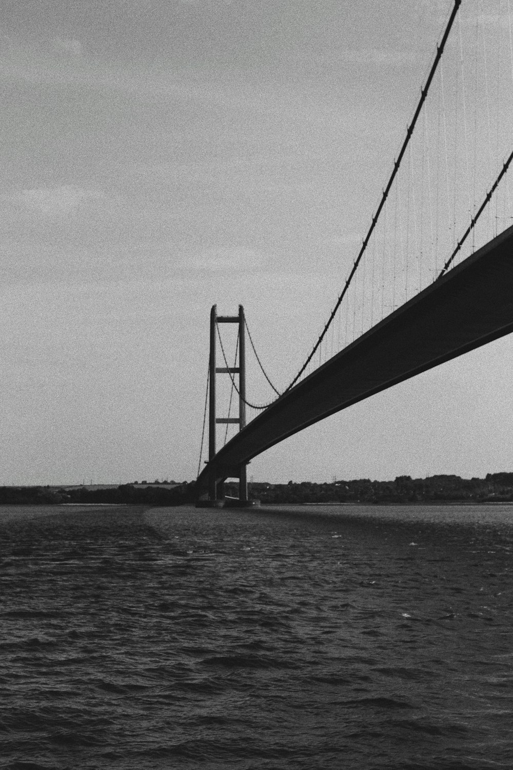 a black and white photo of a bridge over water