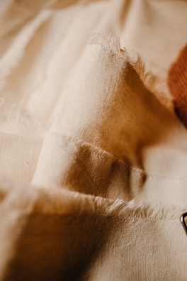 Close-up of elegant fabric textures highlighting fine stitching in a soft beige coat.