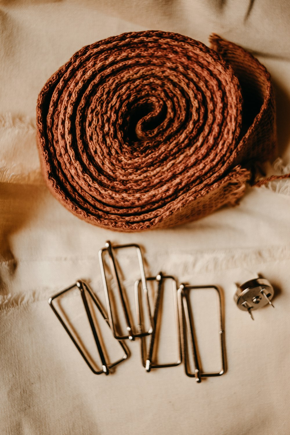 a roll of twine next to a pair of metal clips