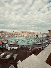 Colorful thermal baths with people relaxing in warm water.