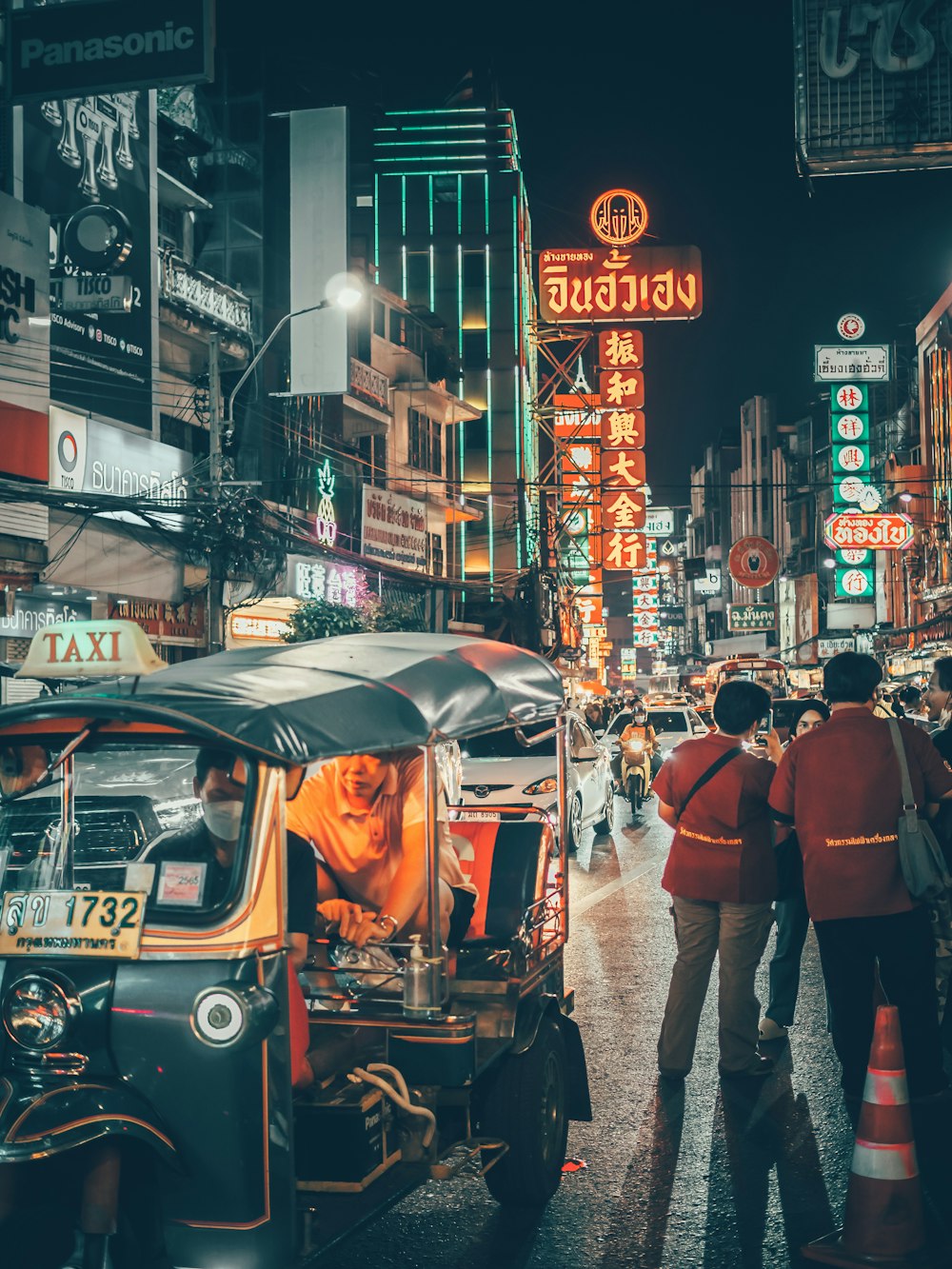 a busy city street at night with people and cars