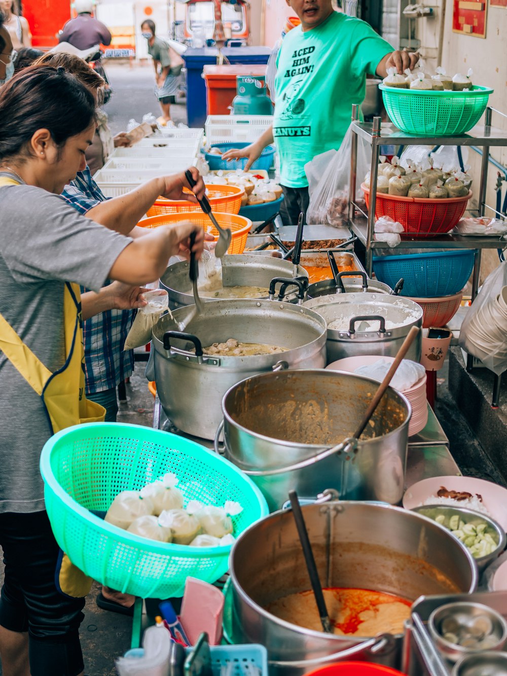 a group of people standing around a table filled with food