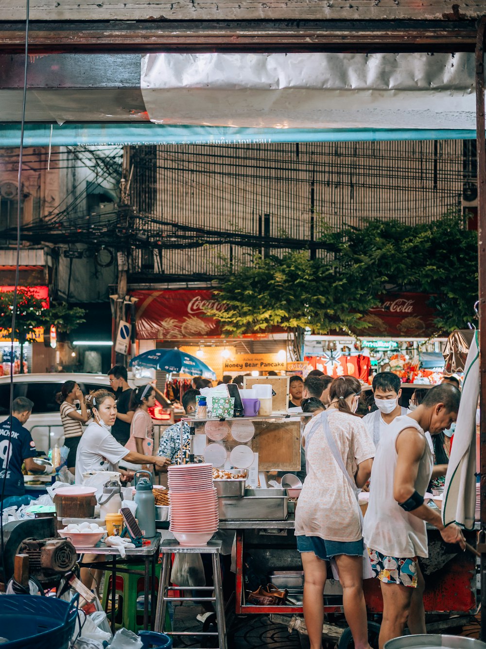 a group of people standing around a food stand