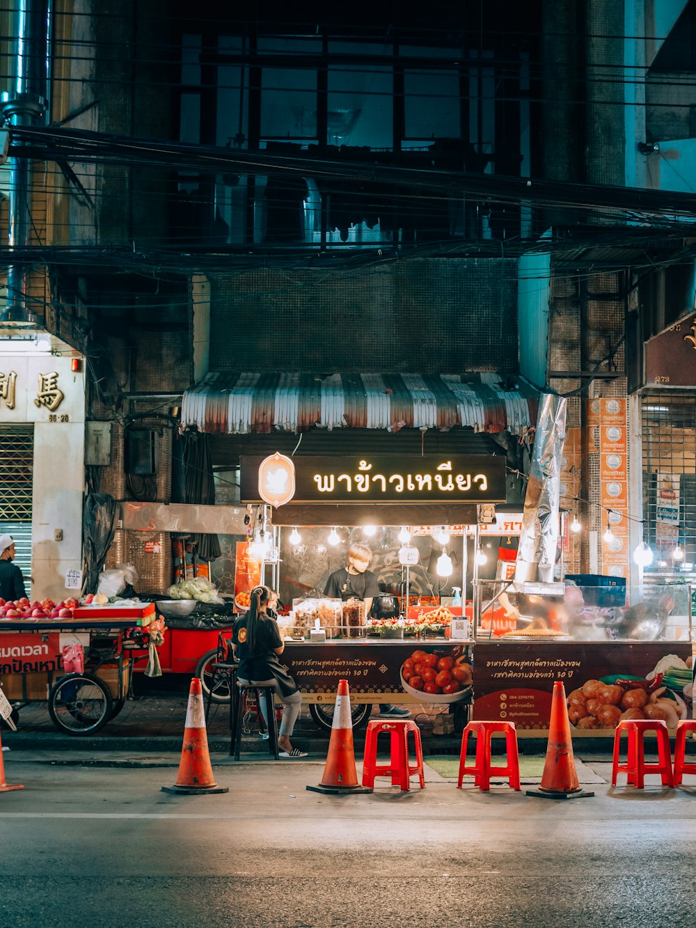 a street scene with traffic cones and a food stand