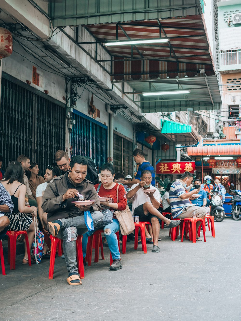 a group of people sitting on top of red chairs