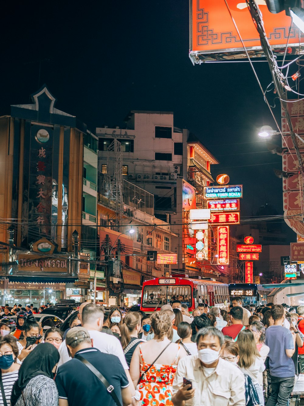 a crowd of people walking down a street at night