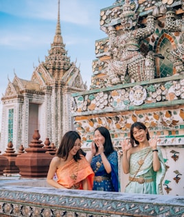 two women standing next to each other in front of a building