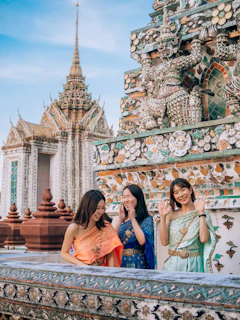 two women standing next to each other in front of a building