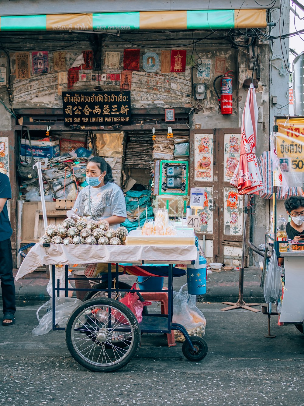 a man selling food on a cart in front of a store