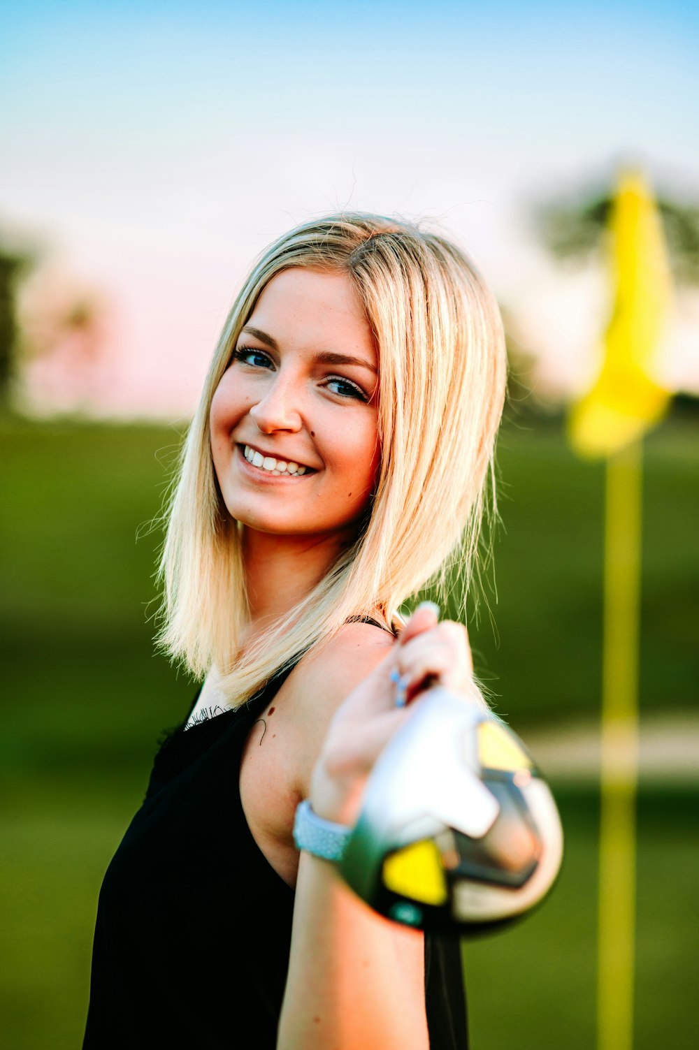 a beautiful blond woman holding a golf club