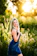 A smiling woman standing in front of a freshly mowed Lexington yard on a sunny day.