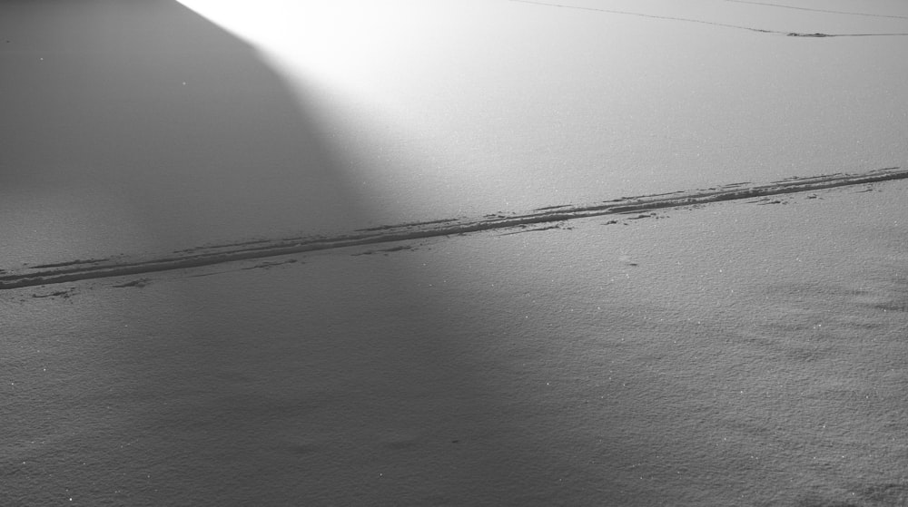 a black and white photo of a snow covered ground