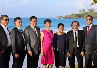 a group of people standing next to each other on a beach