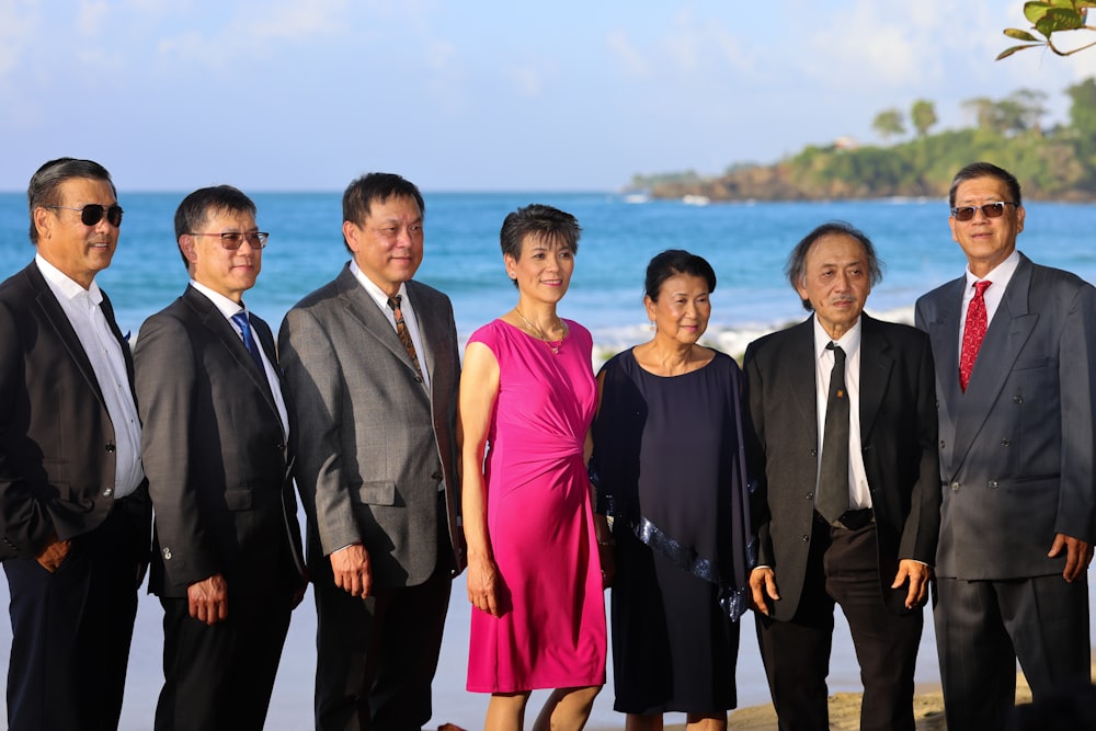 a group of people standing next to each other on a beach